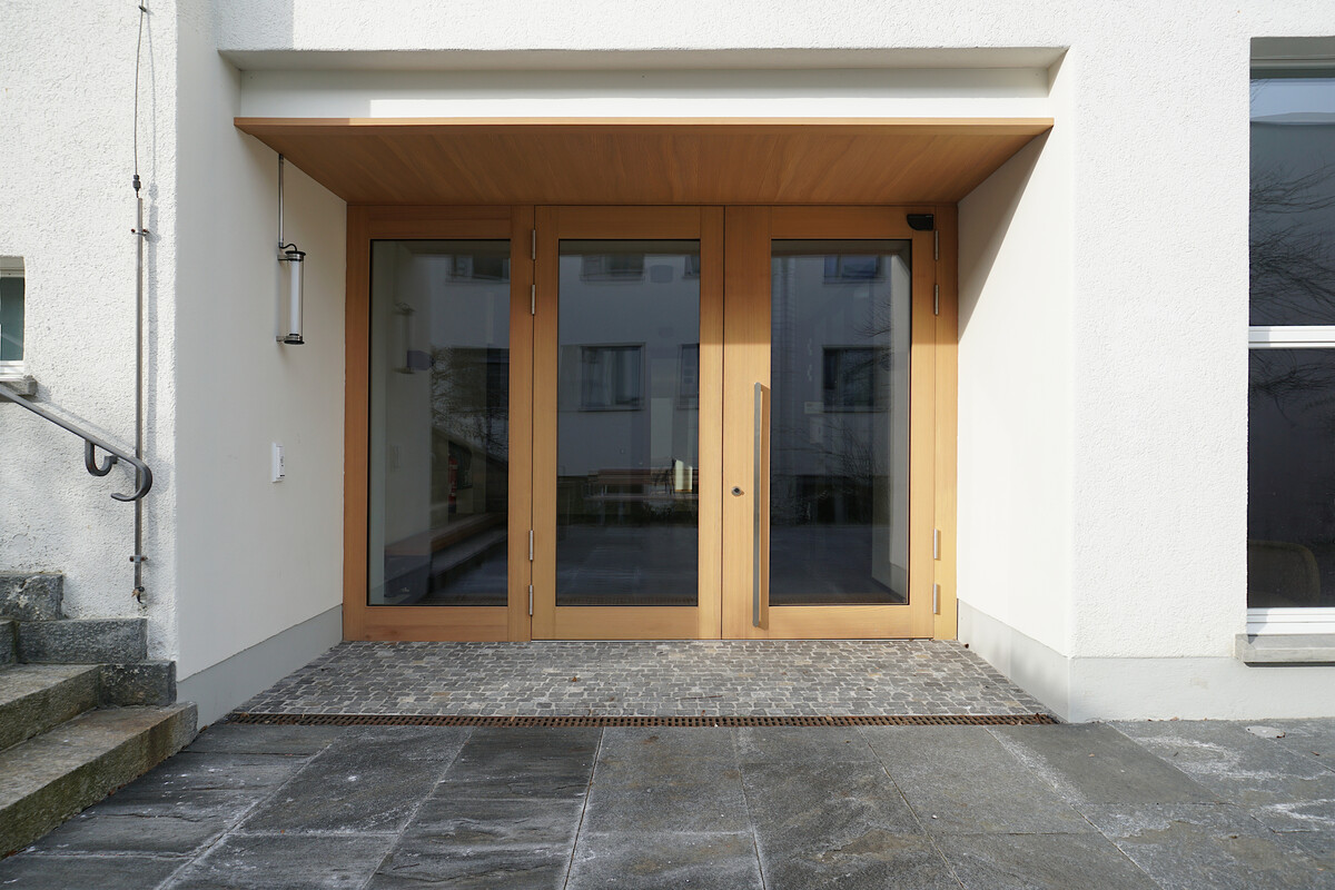 Neuer Haupteingang zum Pfarreizentrum St.Theresia. Türen mit grossen Fenstern in massivem Lärchenholz.
