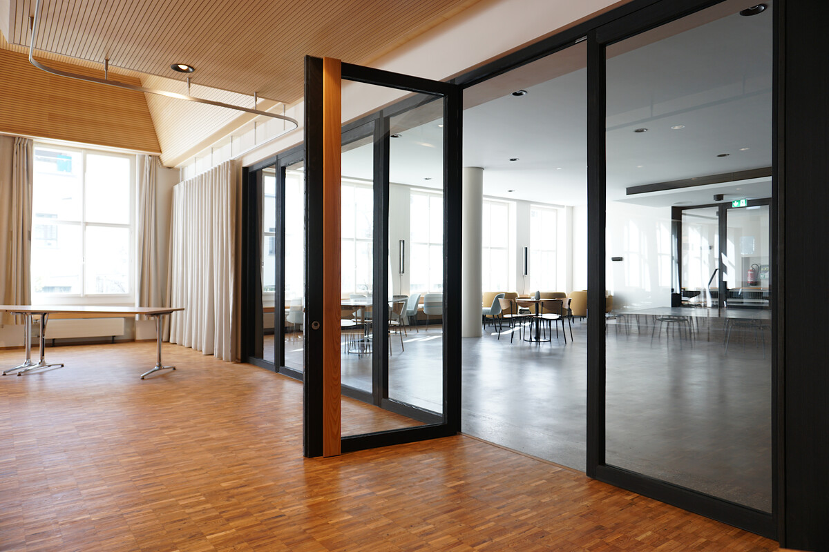 Die grossen Fenster in den Türen schaffen einen Sichtbezug zwischen Foyer und Saal.