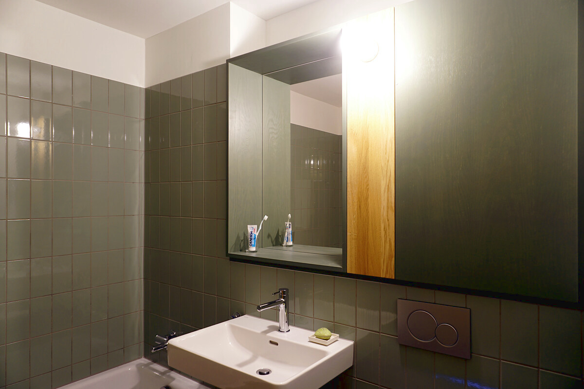 Spiegel mit Holzrahmen und geschlossenem Schrank neben einem Mittelteil aus Eiche